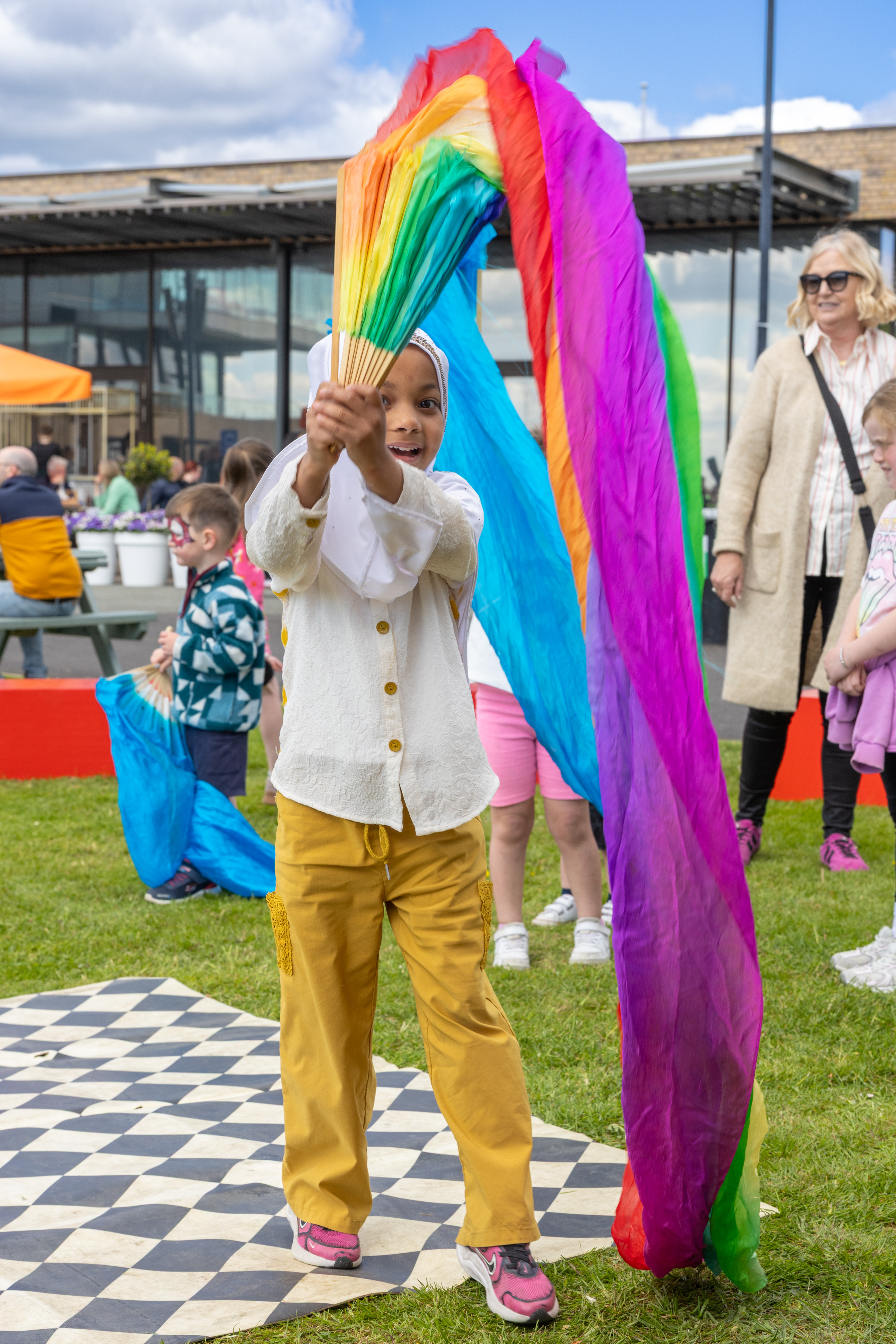 Child playing with rainbow ribbon. 